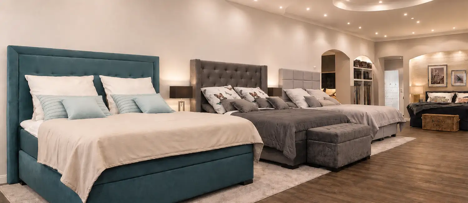 Blick in den Showroom von Sleeping Systems mit drei ausgestellten Luxus-Boxspringbetten zur Fachberatung.
